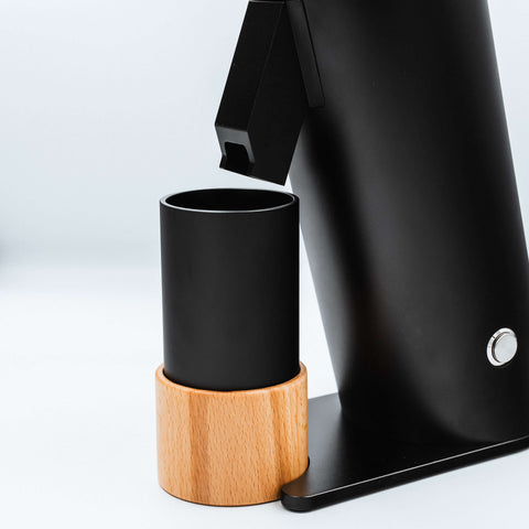 The black metal catch cup on a wooden stand for easy transfer on the DF64V Electric Coffee Grinder