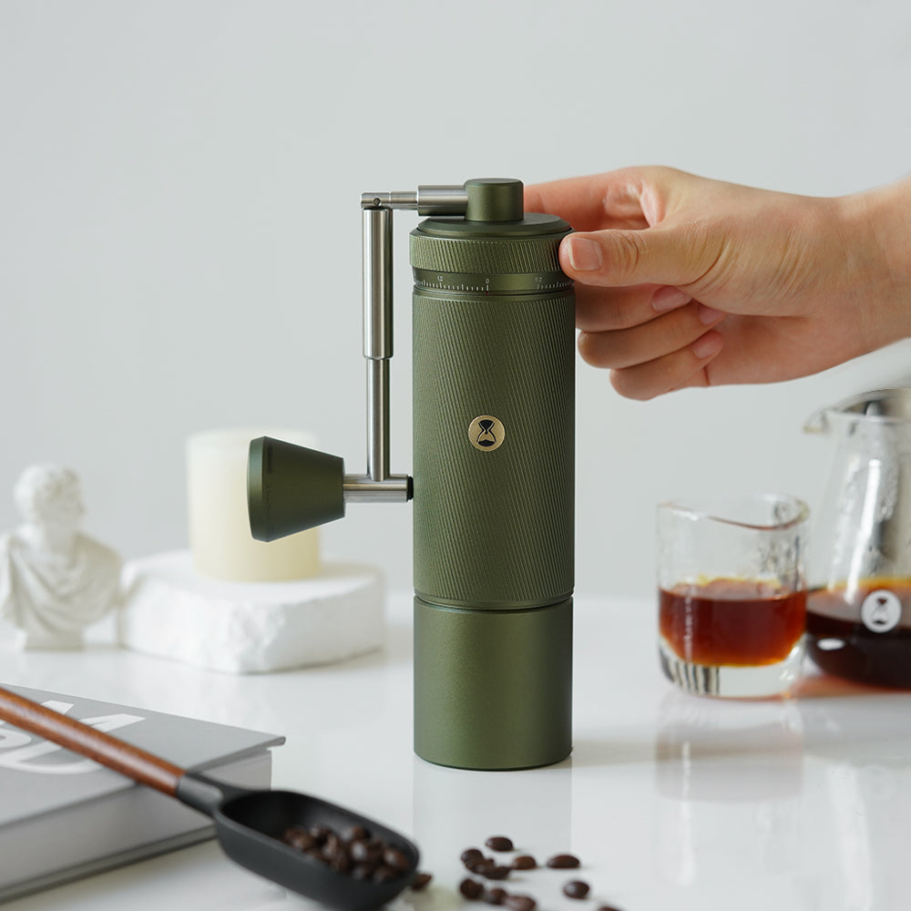 image of someone holding olive green Timemore S3 Chestnut Manual Grinder 