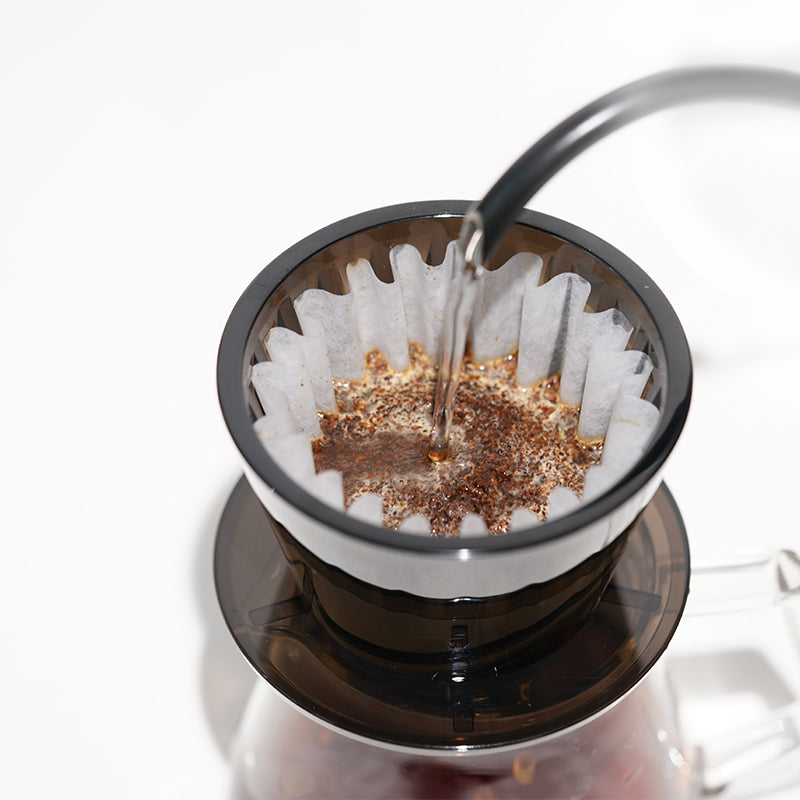 image of someone pouring water into the Timemore B75 Crystal Eye Flat Bottom Dripper/Brewer
