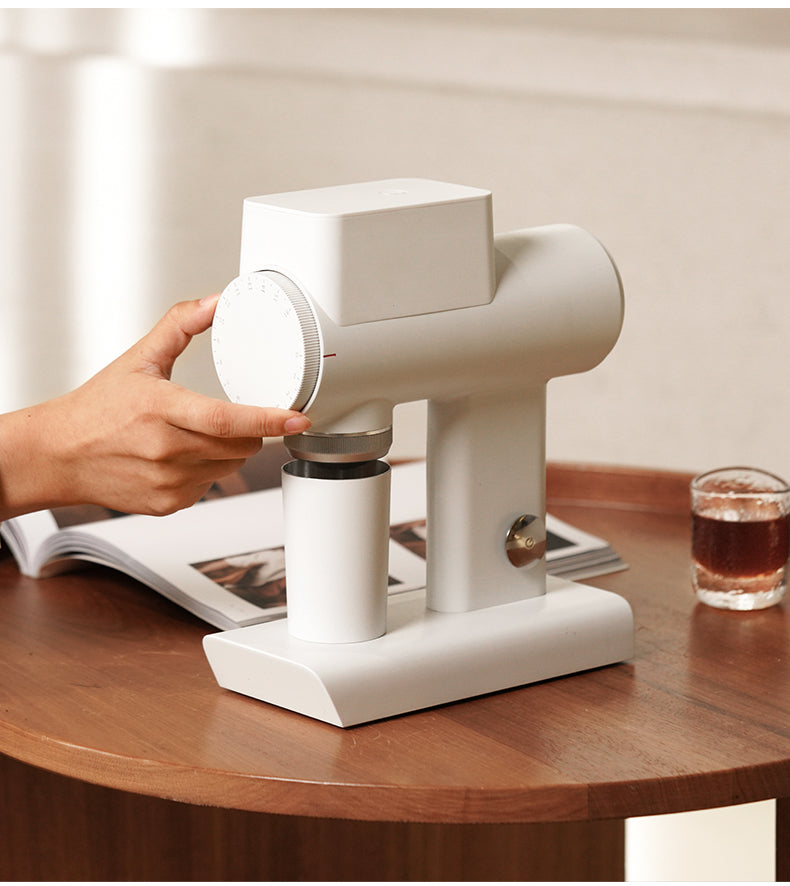 hand adjusting the white Timemore Sculptor 064S Electric Grinder