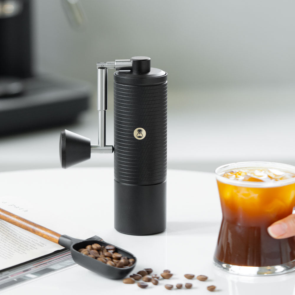image of Timemore C5 Pro Chestnut Manual Grinder on table with cup of coffee and beans
