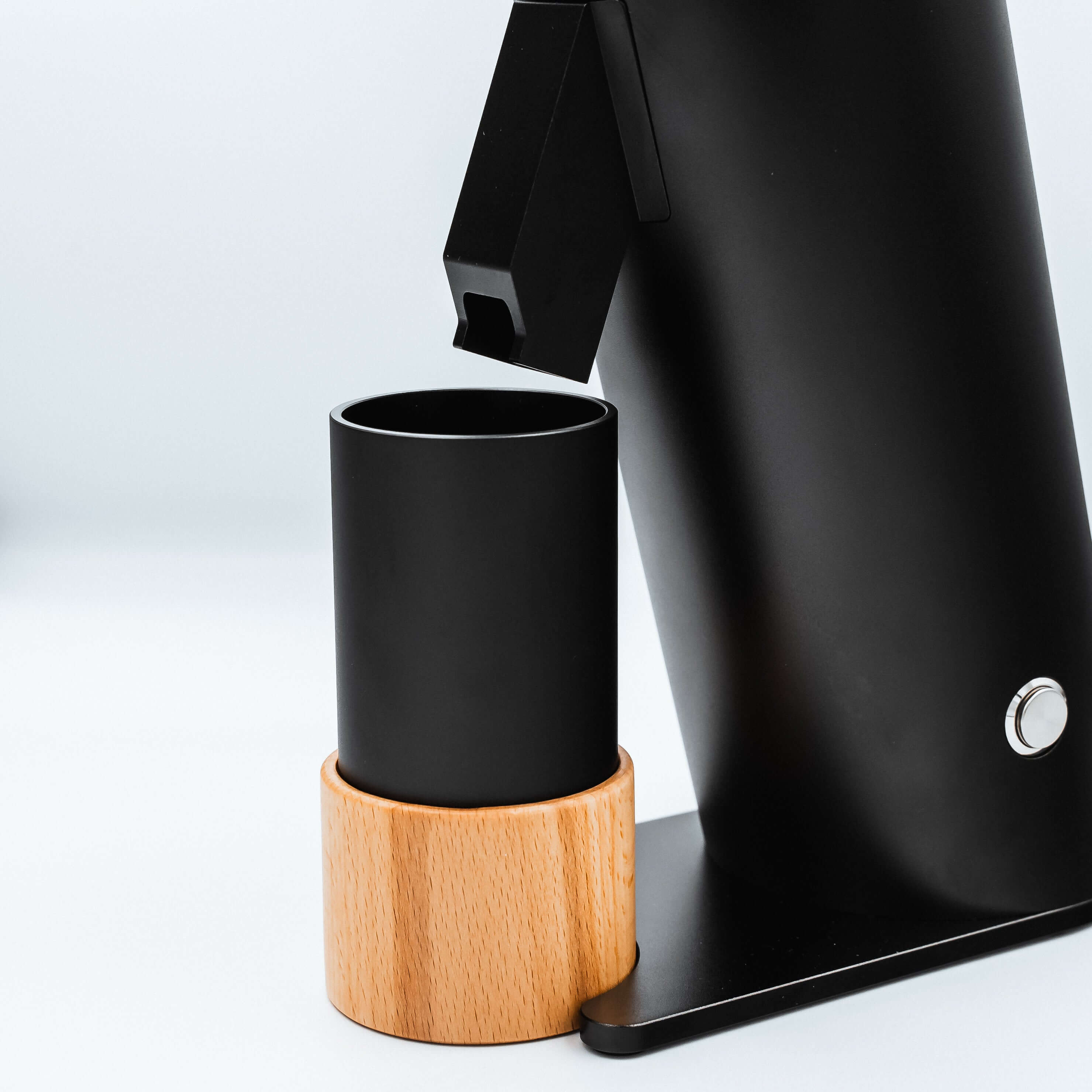 The black metal catch cup on a wooden stand for easy transfer on the DF64V Electric Coffee Grinder